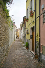 Fototapeta na wymiar A small street between the old houses of Agnone, a medieval village in the Molise region in Italy.