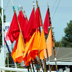 Red and orange flags on poles used by fishermen in the Baltic Sea to mark the locations of their fish traps, on a fishing boat