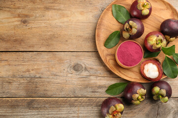 Fototapeta na wymiar Purple mangosteen powder and fruits on wooden table, flat lay. Space for text