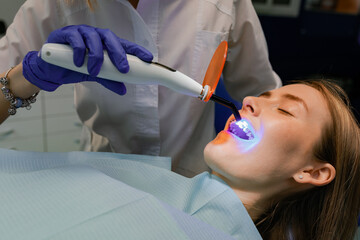 The dentist treats the patient's teeth. Puts braces on a girl. Dentist's office.