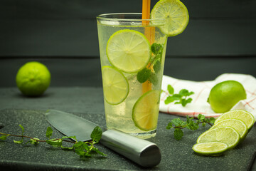 A glass of lemonade and ice with lime