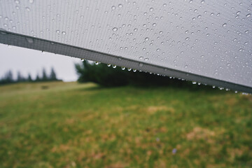 Raindrops on the awning of the tent. Rainy day in the mountains.