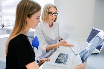 The dentist is talking to the patient in the office. Examines the X-ray. A snapshot of the human jaw.