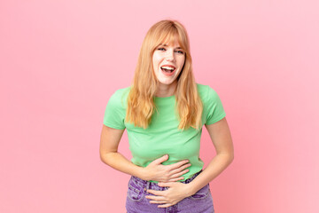 pretty red head woman laughing out loud at some hilarious joke