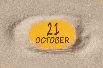 October 21. 21th day of the month, calendar date. Hole in sand. Yellow background is visible through hole. Autumn month, day of the year concept