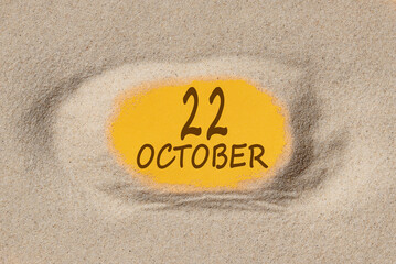 October 22. 22th day of the month, calendar date. Hole in sand. Yellow background is visible through hole. Autumn month, day of the year concept