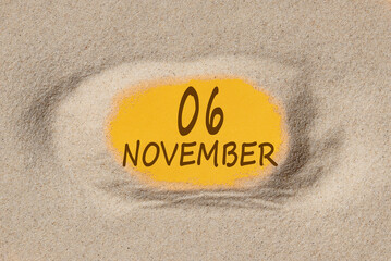 November 6. 6th day of the month, calendar date. Hole in sand. Yellow background is visible through hole. Autumn month, day of the year concept