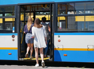 Young women are getting on the bus