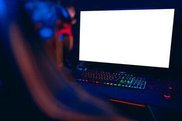 Young man cyber sportsman in headphones looks at computer white screen online stream, copy space mockup for tournament esports © Parilov
