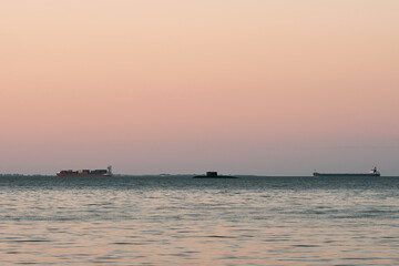 Fototapeta na wymiar Submarine not far from wooden pier in the sea. Military exercise