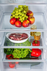 Open fridge full of fresh fruits and vegetables