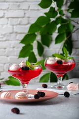 Fruit jelly with fresh mulberries in a glass bowl on a gray background
