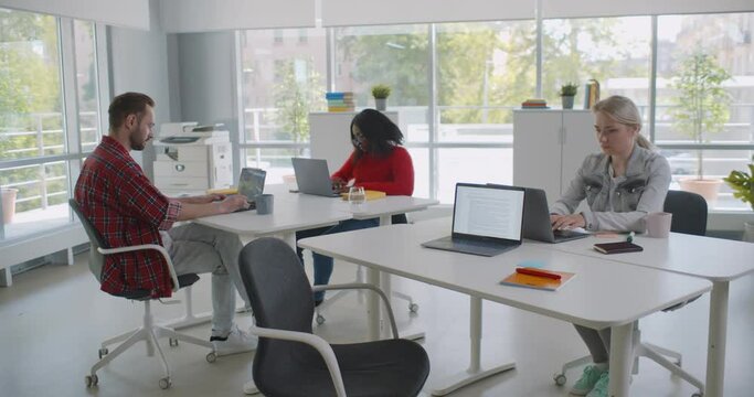 Group Of Diverse Students Or Employees Using Laptop Studying And Working At Open Space Office