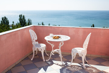 balcony with a beautiful sea view. Coffee cup on table, cakes and biscuits on a plate. Bulgaria, Golden Sands