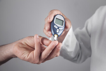 Doctor measuring glucose level in patient.