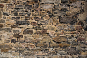 Old stone wall background with textured rocks and stones. Stone backdrop