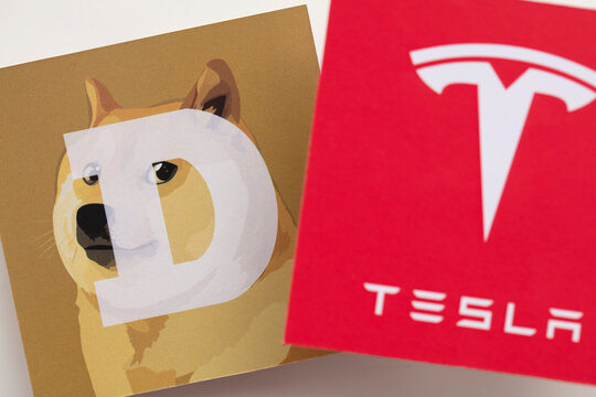 LONDON, UK - June 2021: Tesla electric vehicle and dogecoin cryptocurrency