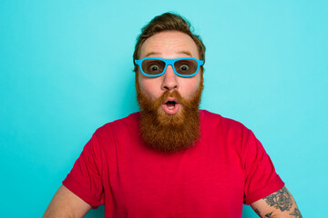 Man with beard and sunglasses is wondered and happy