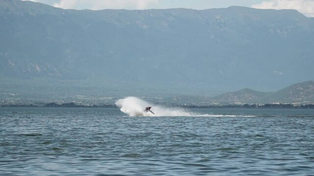 Slow motion of a man on a jetski riding the jet towards the sea waves, adrenaline anc vacation concept