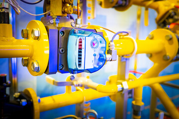 Yellow gas equipment. Gas yellow pipes with a meter. Sensor shows amount of consumed methane. Fragment of boiler equipment close-up. Fragment of gas pipe in boiler room. Equipment for boiler room - obrazy, fototapety, plakaty