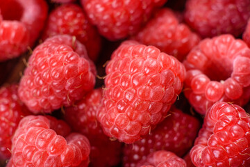 Delicious fresh juicy red raspberries on a dark table