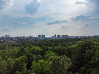 Fototapeta na wymiar Aerial view on green summer Kharkiv city center Sarzhyn Yar park. Botanical garden with high trees and scenic cloudscape in residential area