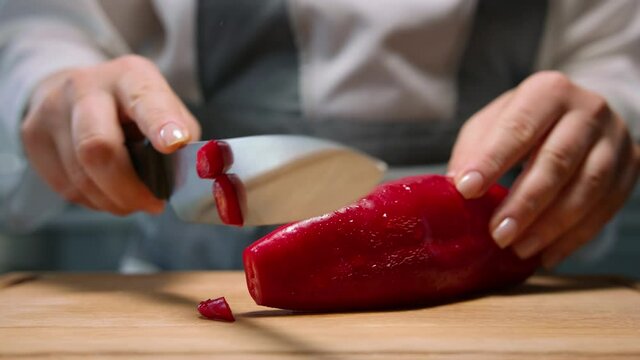 Female hands slicing red ramiro pepper. Close up