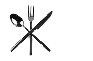 black cutlery knife, fork, spoon crossed on white background with copy space