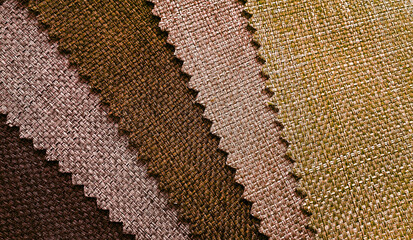 close up detail of multi color of linen or woolen fabric texture samples. brown color tone of upholstery and drapery fabric. cotton canvas fabric background for vintage concept.