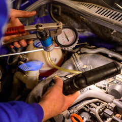 Obraz premium Professional car mechanic working in a car service, computer diagnostics of the bonnet space in the car.