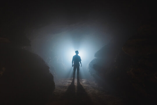 Unrecognizable man standing in narrow cave