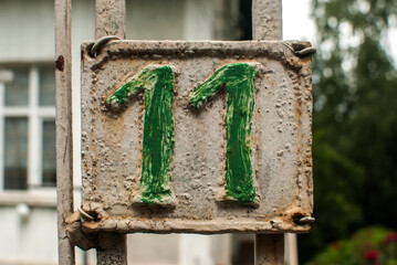 Old retro weathered cast iron plate with number 11 closeup