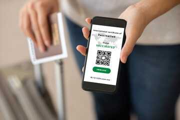 Smartphone on hand of person traveler show international certification of Vaccination in the airport. Certificate of vaccinated coronavirus. Travel concept during COVID-19 pandemic.