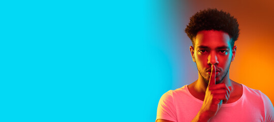 Portrait of a young african man at studio. Fashion male model in colorful bright neon lights.
