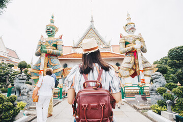Asian backpacker women wear sun hat traverl in temple of buddha