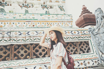 Fototapeta premium Asian backpacker women wear sun hat traverl in temple of buddha