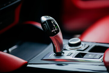 Obraz premium Automatic gear stick of a modern car. Modern car red interior details. Close up view.