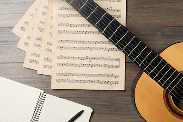 Fototapeta na wymiar Composition with guitar and music notations on wooden table, flat lay