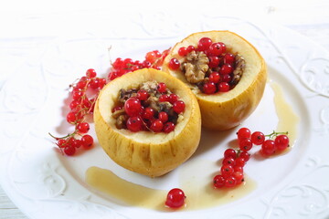 Baked apples with honey, walnuts, currants on a white background