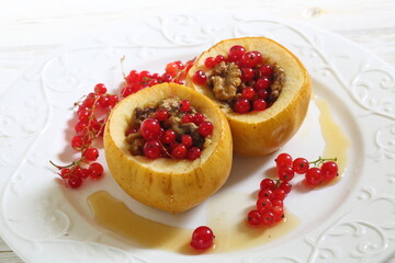 Baked apples with honey, walnuts, currants on a white background
