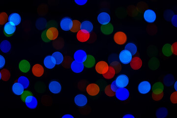 Multicolored bokeh on a black background. Abstract background