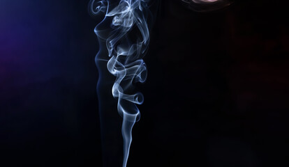 A jet of gray cigarette smoke on a black background
