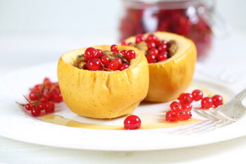 Baked apples with honey, walnuts, currants on a white background