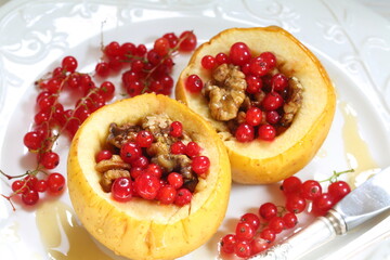 Baked apples with honey, walnuts, currants on a white background