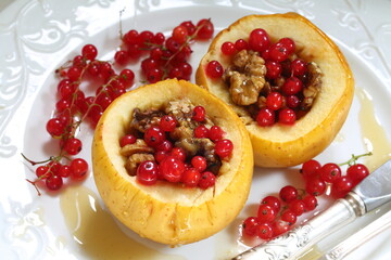 Baked apples with honey, walnuts, currants on a white background