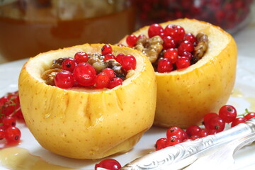 Baked apples with honey, walnuts, currants on a white background