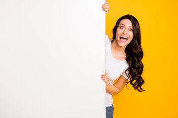 Portrait of attractive amazed cheerful girl holding big board copy space ad offer isolated over...