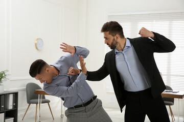 Emotional colleagues fighting in office. Workplace conflict - obrazy, fototapety, plakaty