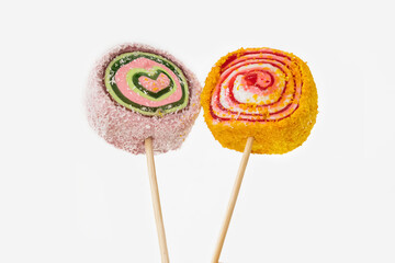 Two colorful lollypops on wooden sticks on white background