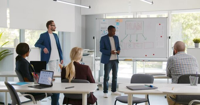 Diverse business partners presenting startup project to investors in modern office